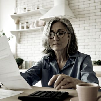 a lady holding a paper and using a calculator